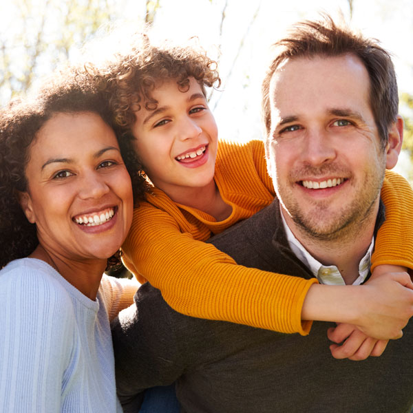 Family smiling together after a visit to Dentistry By Design